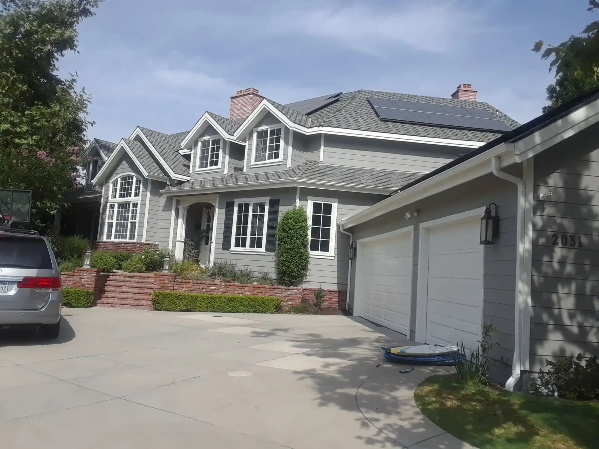 Gray two-story home with crisp white trim after an exterior repaint